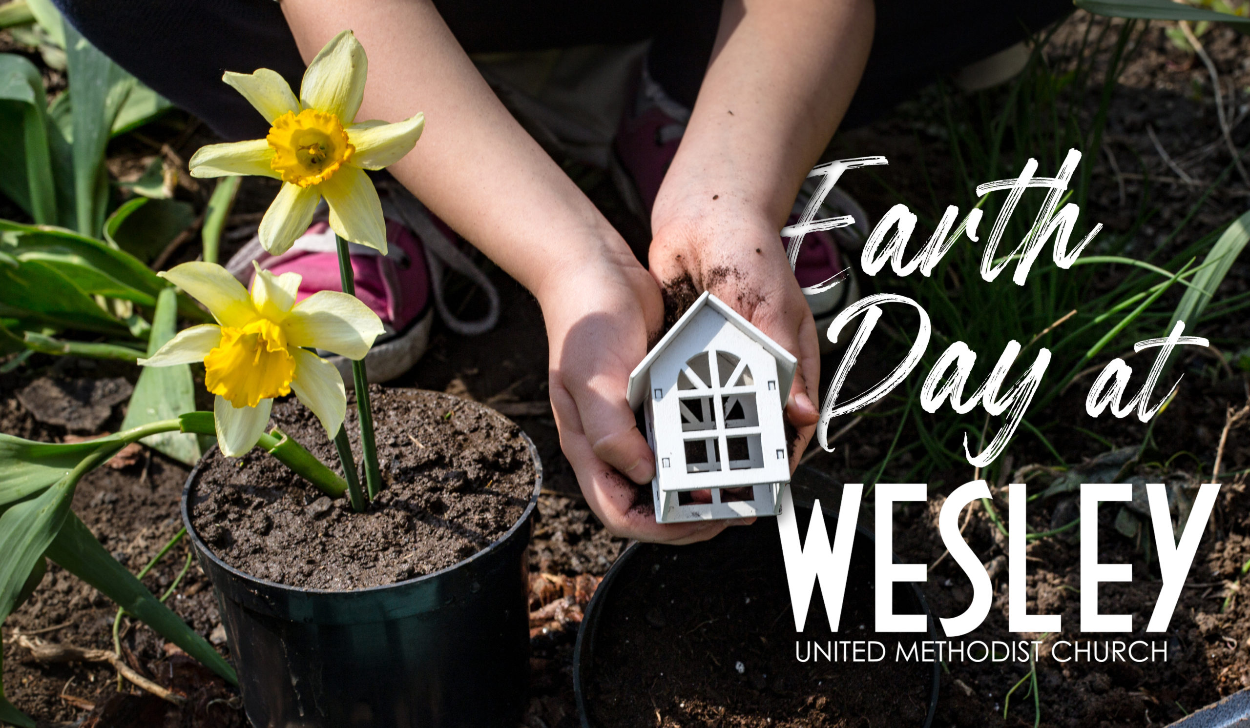 Earth Day .A child in the background of the garden holding a small wooden house. Wooden letters with the inscription home